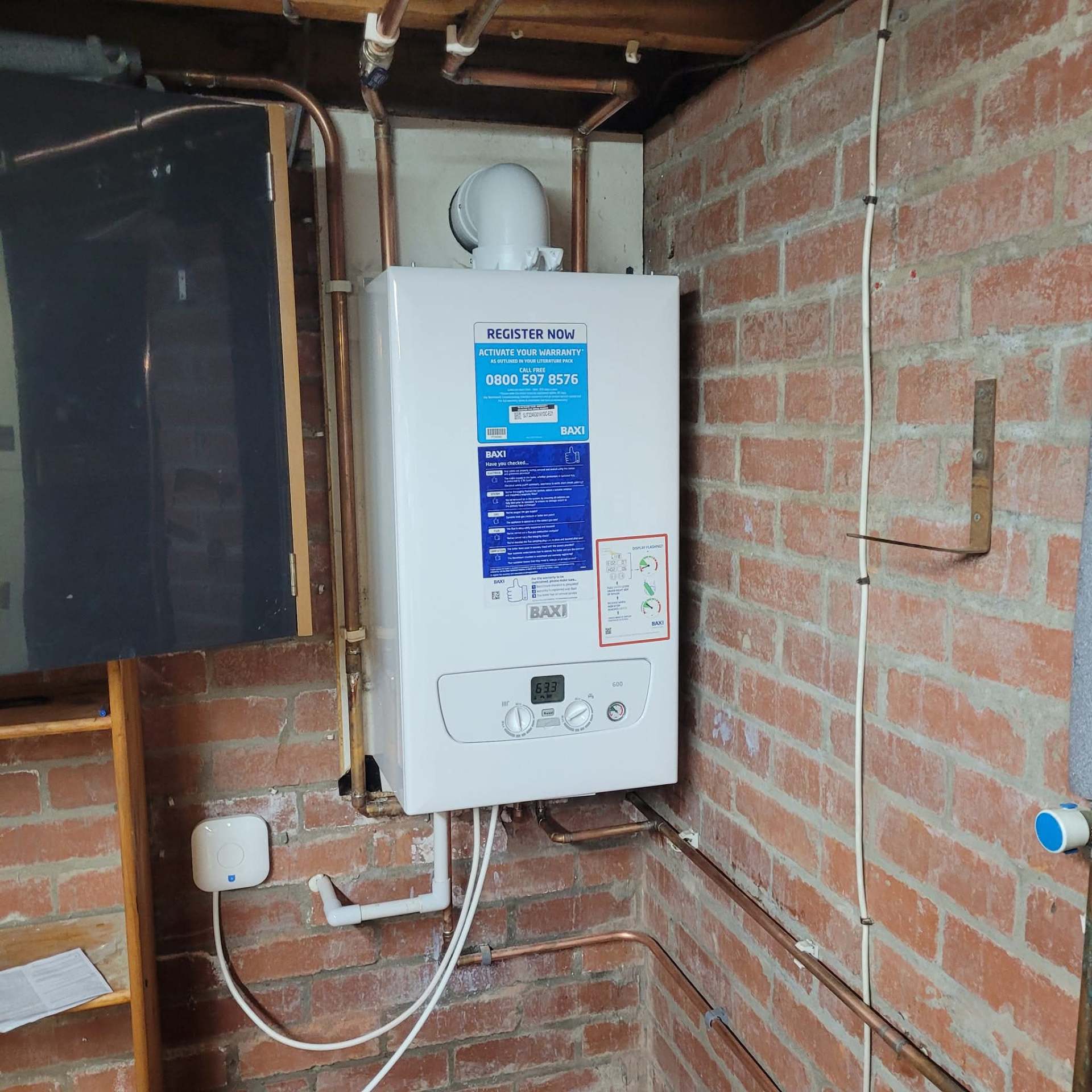 Combi boiler installed on a brick wall in a garage conversion with new flue